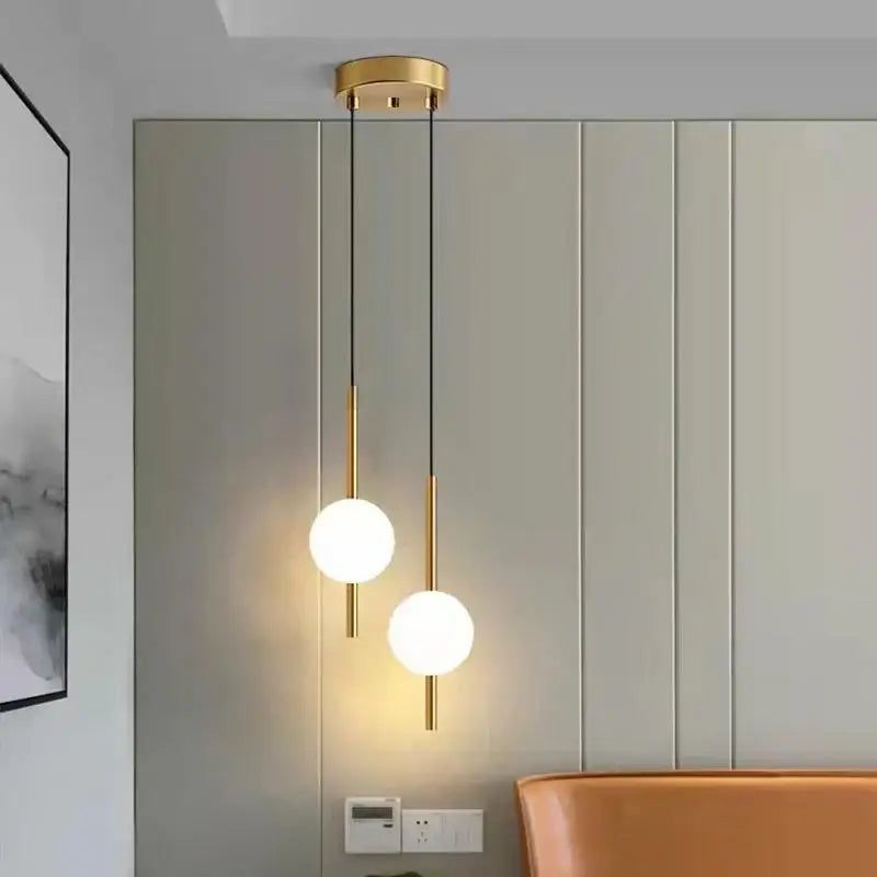 Modern gold glass ball pendant light with two frosted spherical bulbs suspended by slender rods for bedroom decorbites decor