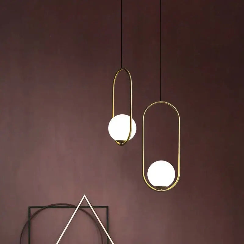 Two minimalist pendant lights with gold-toned metal frames and frosted glass spheres for dining room decorbites glass ball pendant