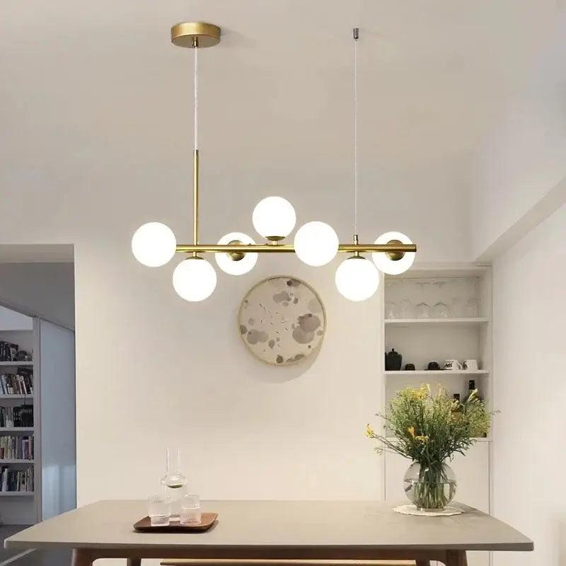 Modern gold pendant light with six frosted glass ball bulbs in linear design perfect for dining room decorbites glass ball