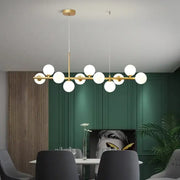 Modern gold glass ball pendant light chandelier with frosted globe bulbs in linear design for dining room decorbites