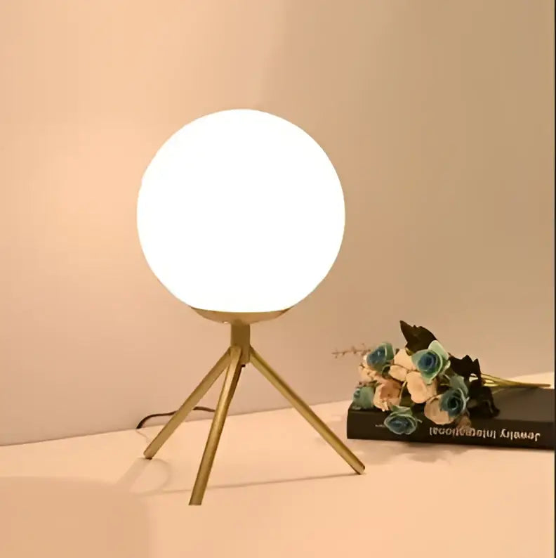 Modern gold glass ball table lamp with a sleek white frosted glass globe and minimalist gold tripod base decorbites glass ball