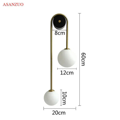 Modern wall lamp by Asanzuo with brass curved arm and dual matte white glass ball gold shades for bedroom decorbites glass ball