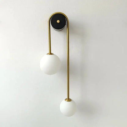 Modern wall lamp with sleek gold-finished metal frame and two frosted white glass ball shades decorbites glass ball gold