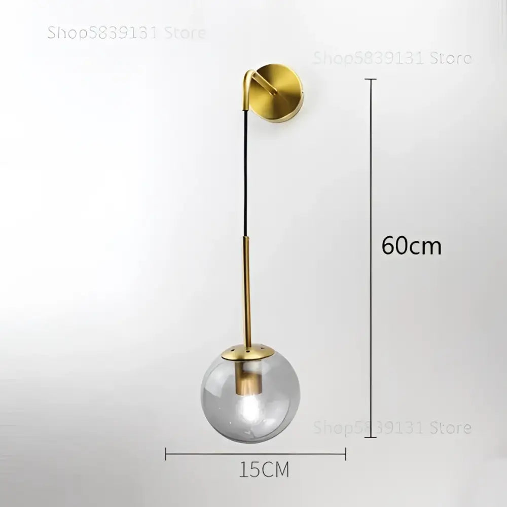 Modern gold glass ball wall lamp featuring a gold-toned metal stem and clear glass globe for elegant decorbites glass ball decor