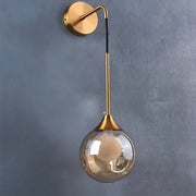 Modern gold glass ball wall lamp with curved arm and smoked glass shade for elegant bedroom decorbites glass ball sconce