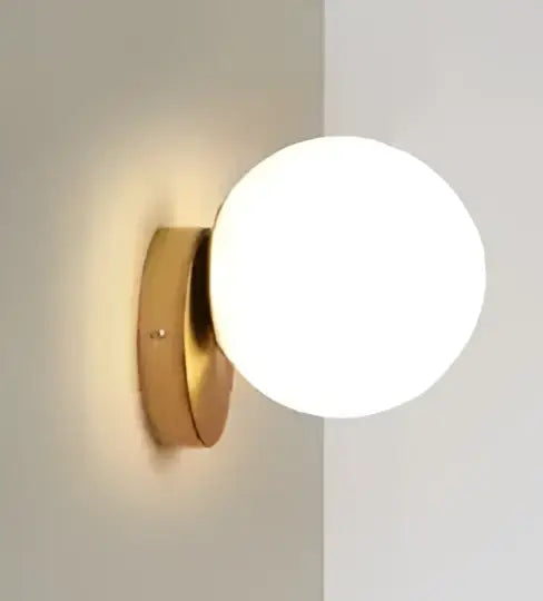 Modern gold glass ball wall lamp with a frosted glass globe for bedroom decor by decorbites glass ball wall lamp