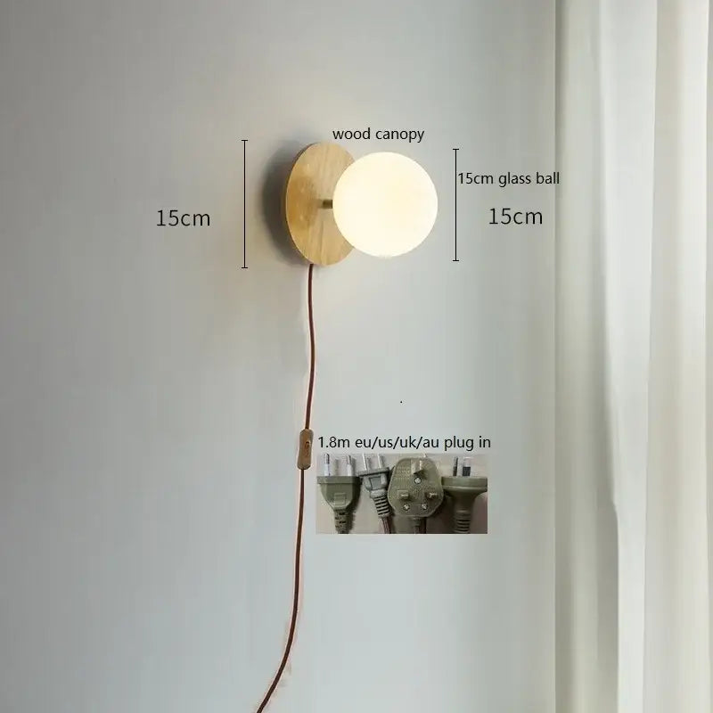Minimalist wall lights with natural wood canopy and 15cm frosted glass ball featuring adjustable brown cord decorbites glass ball
