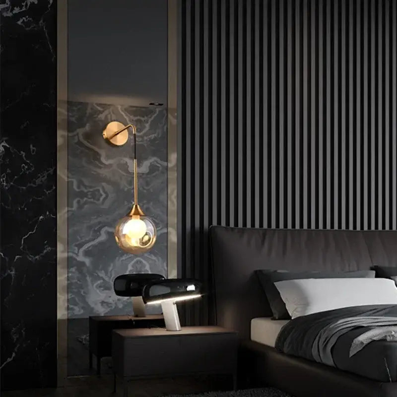 Modern gold glass ball wall sconce featuring a gold-toned metal base and spherical glass globe for bedroom decorbites glass ball lighting