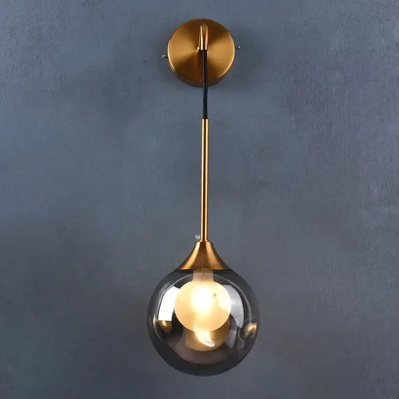 Modern gold glass ball wall sconce with a sleek smoked glass shade and minimalist metal stem for bedroom decorbites glass ball lighting