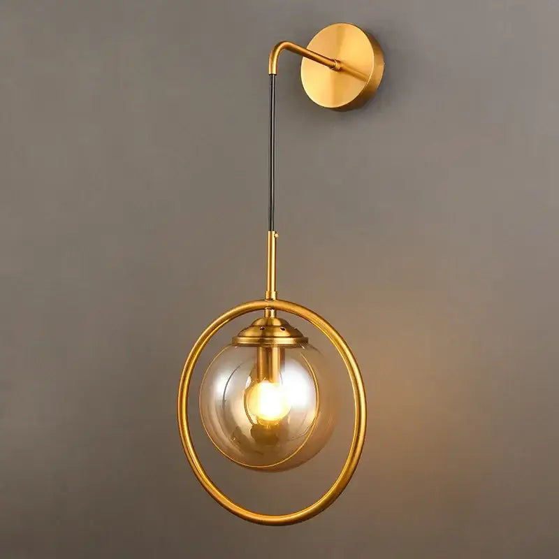Modern gold glass ball wall sconce light fixture with a brass ring and circular globe by decorbites for bedroom decor