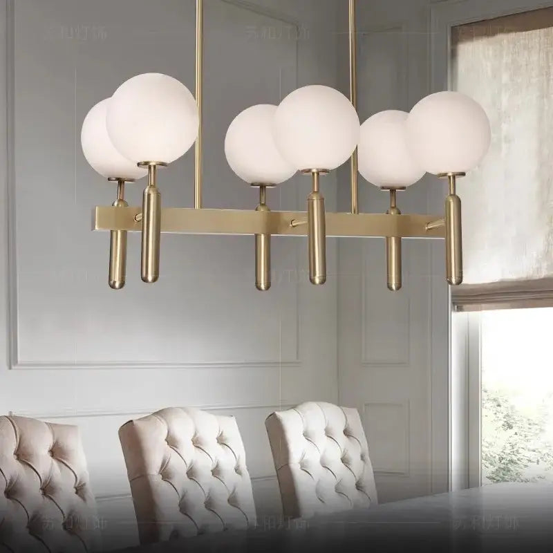 Modern gold glass balloon chandelier with five frosted glass globes on a sleek horizontal bar for dining room decorbites glass balloon