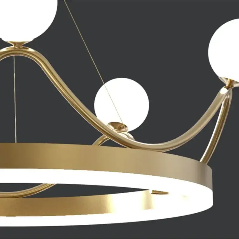 Modern gold glass crown chandelier pendant with sleek curved arms and three white spherical glass shades for bedroom