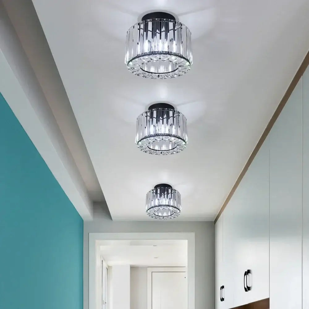 Three modern crystal flush mount chandelier ceiling lights with black metal bases and clear faceted glass elements