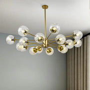 Modern gold glass led chandelier with clear textured glass spheres designed as a dining room sphere pendant light