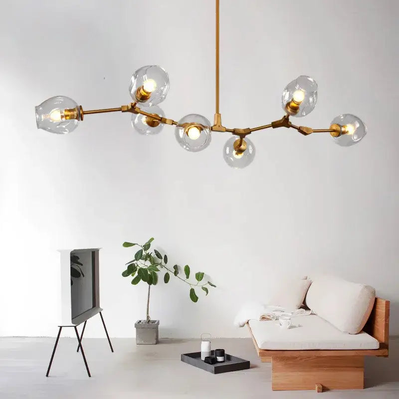 Modern gold glass pendant lights featuring gold-toned chandelier design with clear glass globe bulbs for dining room