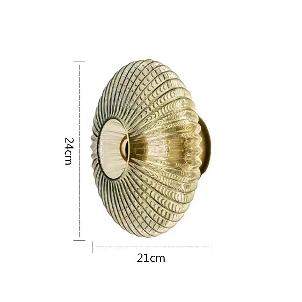 Antique brass shell-shaped door knob with radial ridges complements modern gold glass ripple led wall lamps for bedroom decoration