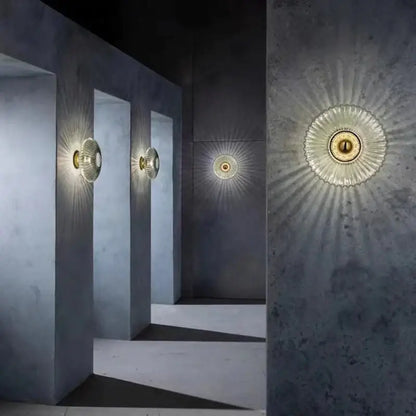 Modern gold-toned wall lamps with sunburst pattern glass ripple led diffuser and metallic finish for bedroom decoration