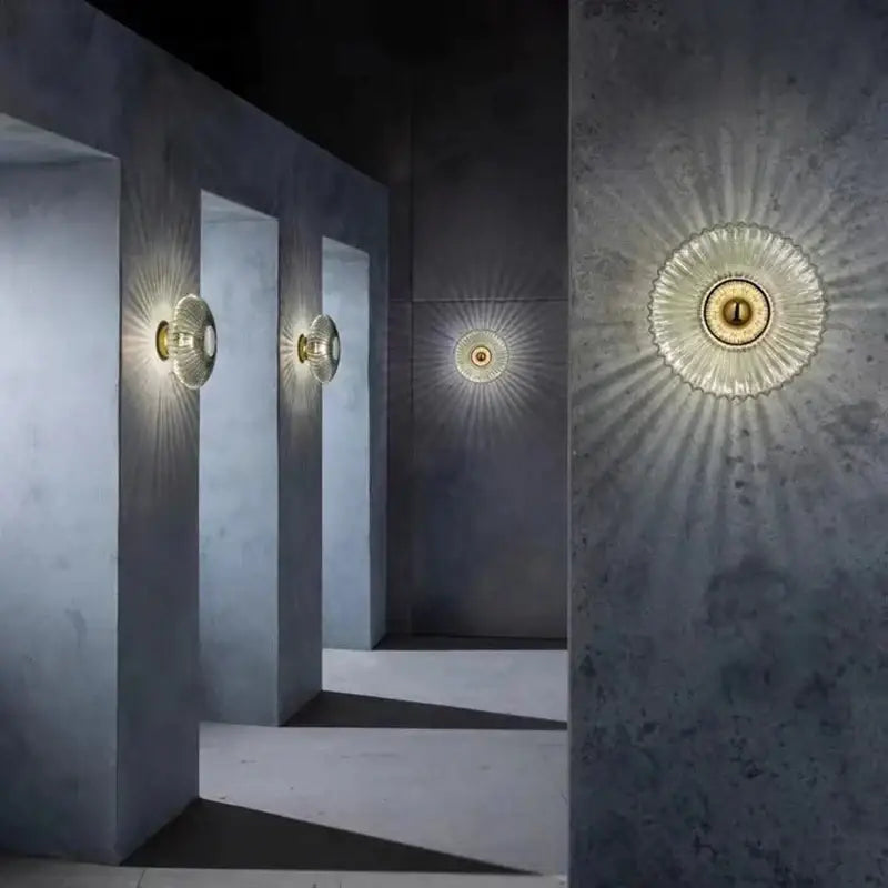 Modern gold-toned wall lamps with sunburst pattern glass ripple led diffuser and metallic finish for bedroom decoration