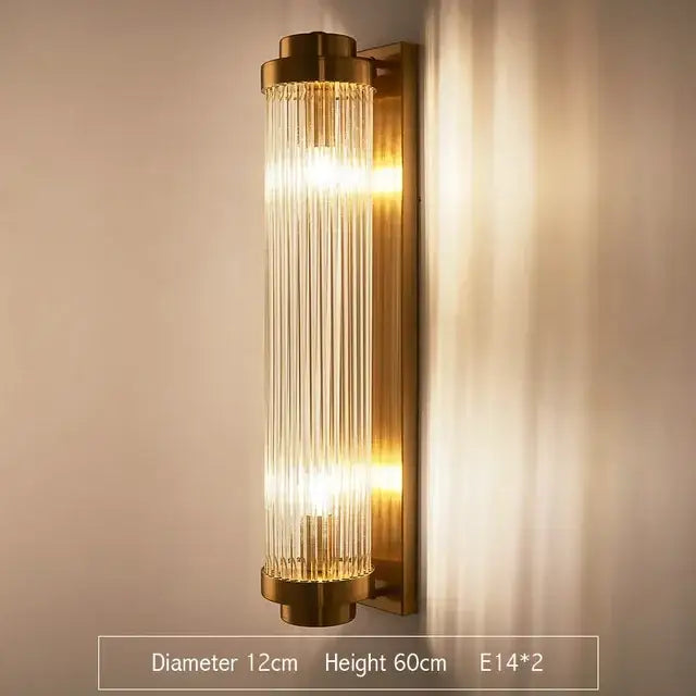 Modern gold brass-finished wall sconce with vertical glass rod crystal rods emitting warm light for bedroom use