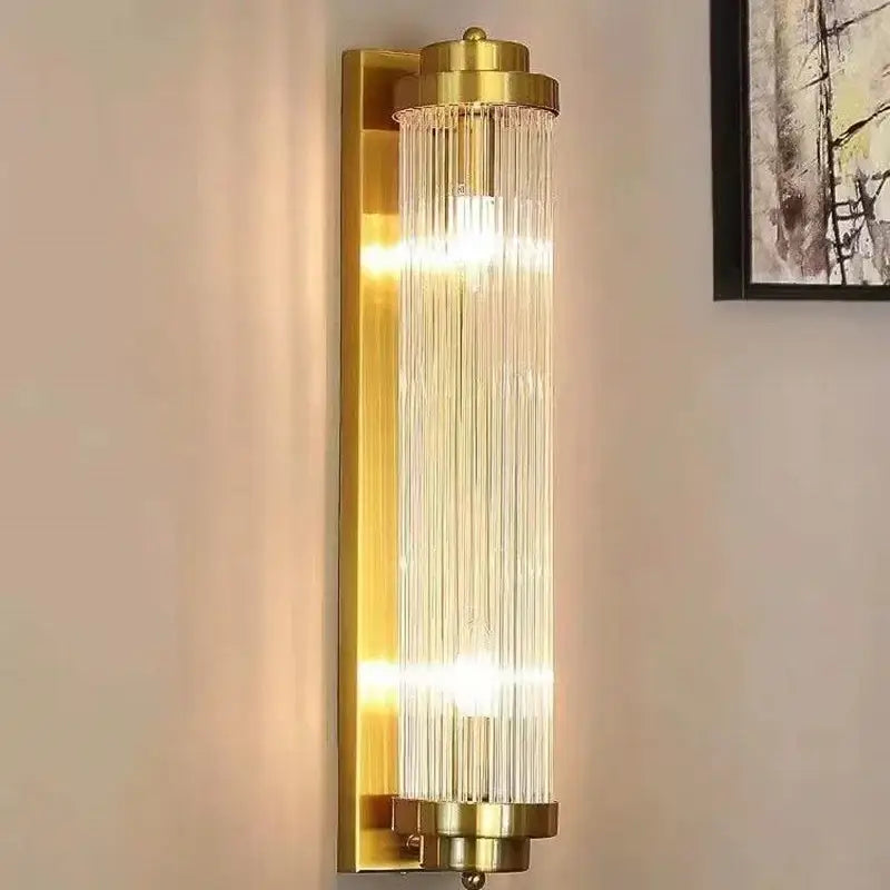 Modern gold wall sconce featuring vertical glass rod crystal prisms for elegant bedroom lighting