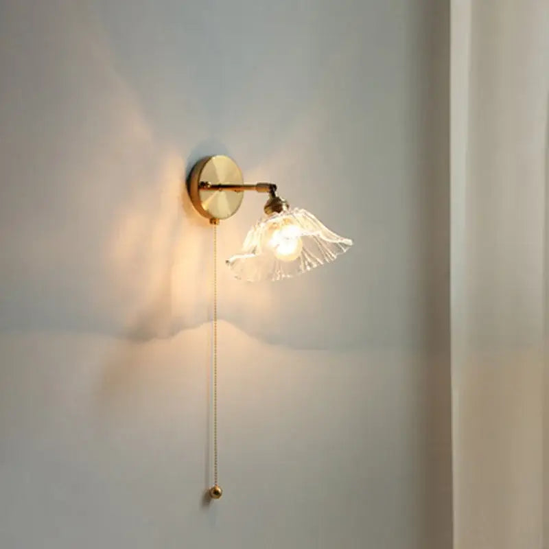 Modern gold brass wall light with a fluted glass shade and elegant pull chain for bedroom led wall lighting
