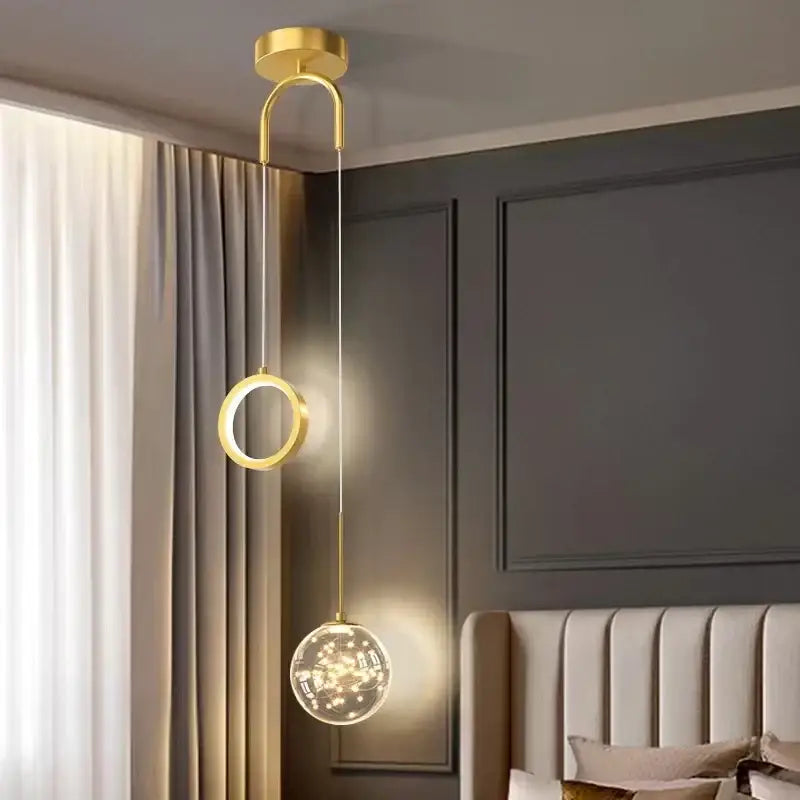 Modern gold glass starry led pendant light featuring a circular ring and spherical globe with warm led lights for bedroom