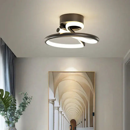 Modern gold heart line led chandelier with two intertwined brushed metal rings emitting soft white glow for bedroom ceiling light