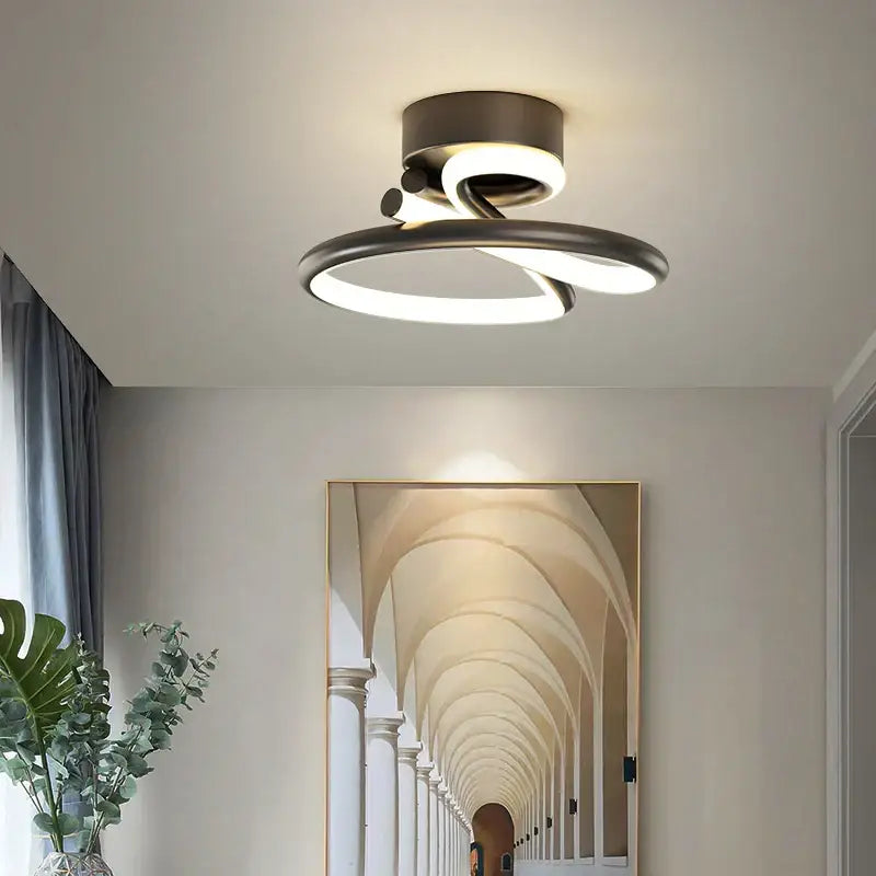 Modern gold heart line led chandelier with two intertwined brushed metal rings emitting soft white glow for bedroom ceiling light