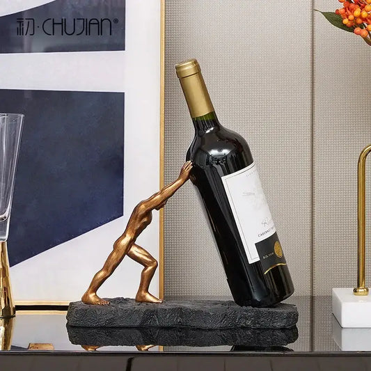 Modern gold hercules figurines wine rack with a muscular man pushing a dark glass bottle on a textured black base
