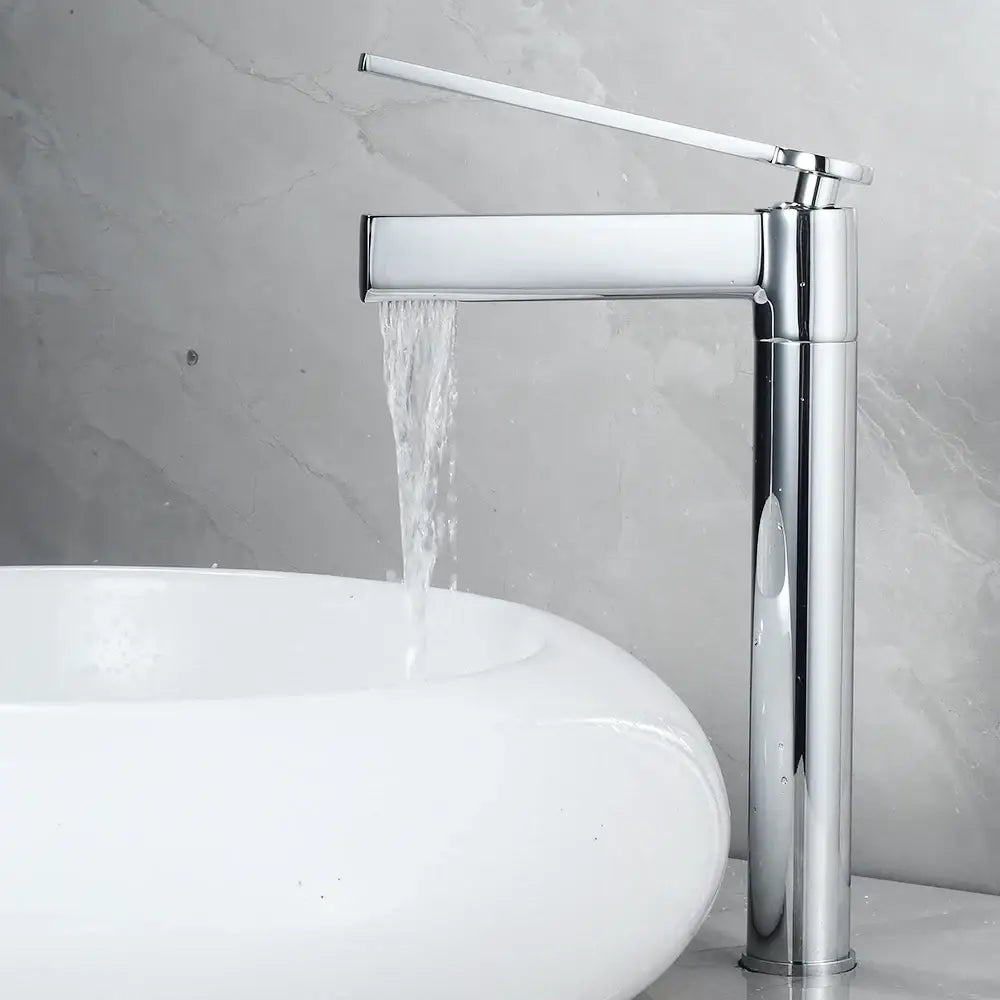 Modern chrome finished waterfall basin faucet with a sleek tall design and minimalist handle in decorbites brass deck mounted style