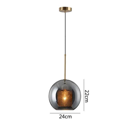 A modern gold honeycomb glass pendant light with a dark smoked glass globe and brass rod for dining room fixtures