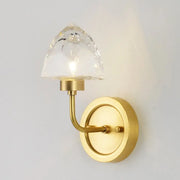 A sleek gold ice cube wall light with a faceted crystal shade for modern bedroom wall lighting
