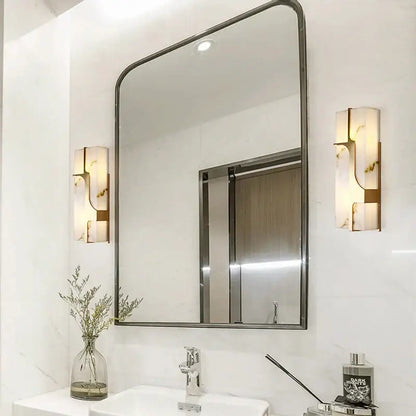 Rectangular bathroom mirror with dark metallic frame and rounded corners complementing decorbites imitation marble led wall lamp