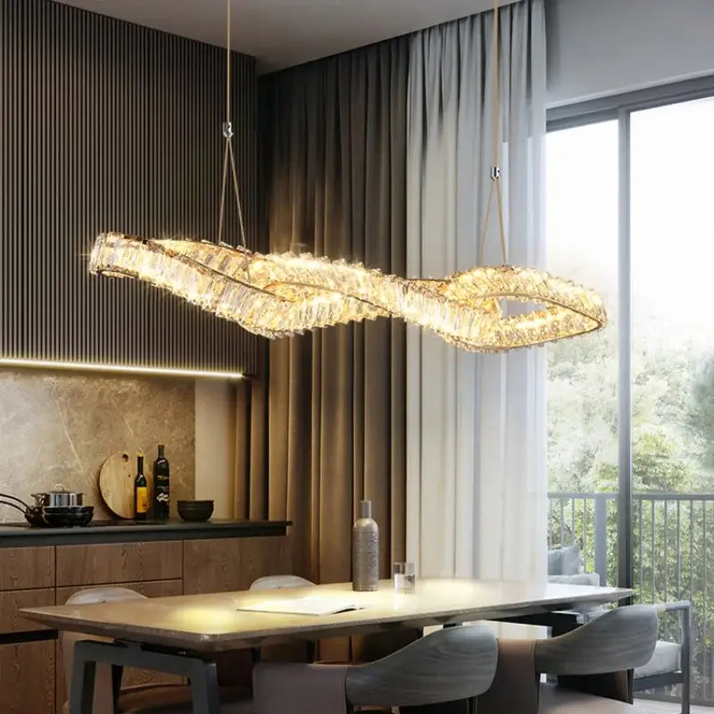 A modern gold-toned decorbites crystal led pendant with an elegant infinity-loop design for dining room decor