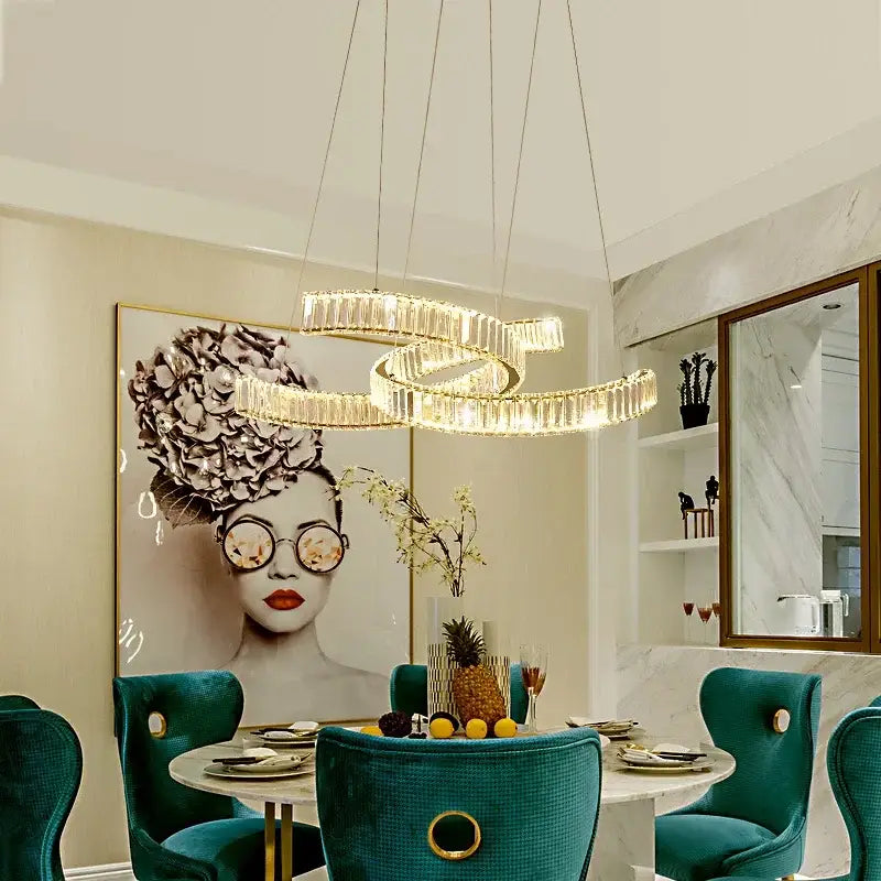 A modern gold-toned decorbites crystal led pendant light with intertwined circular design for dining room decor