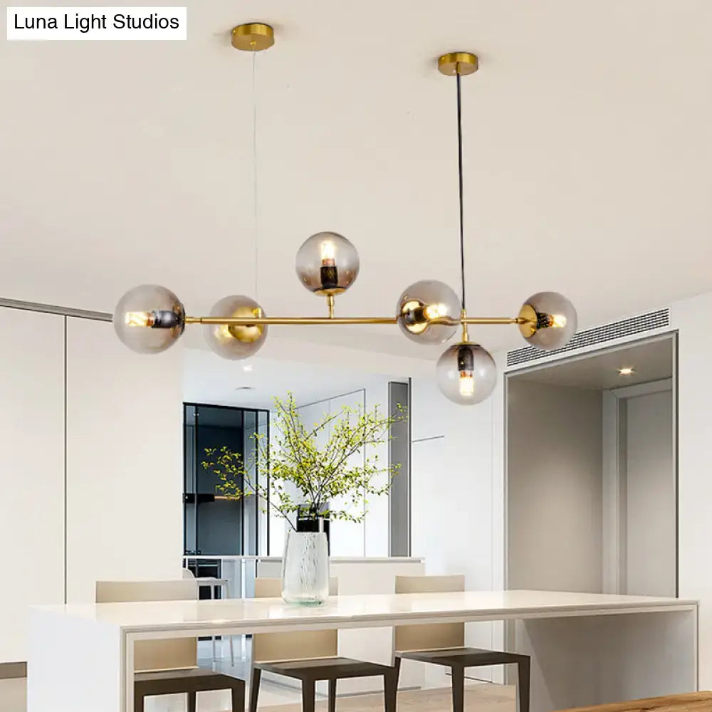 Modern gold island pendant light with brass and smoked glass spherical bulbs for dining room illumination
