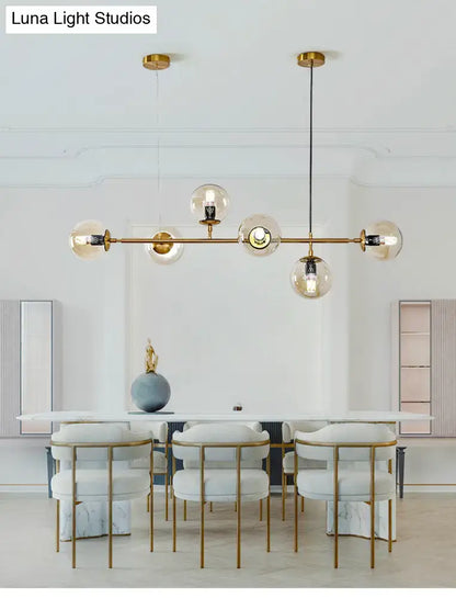 Modern gold island pendant light with gold-tone metal and multiple glass globes for dining room illumination