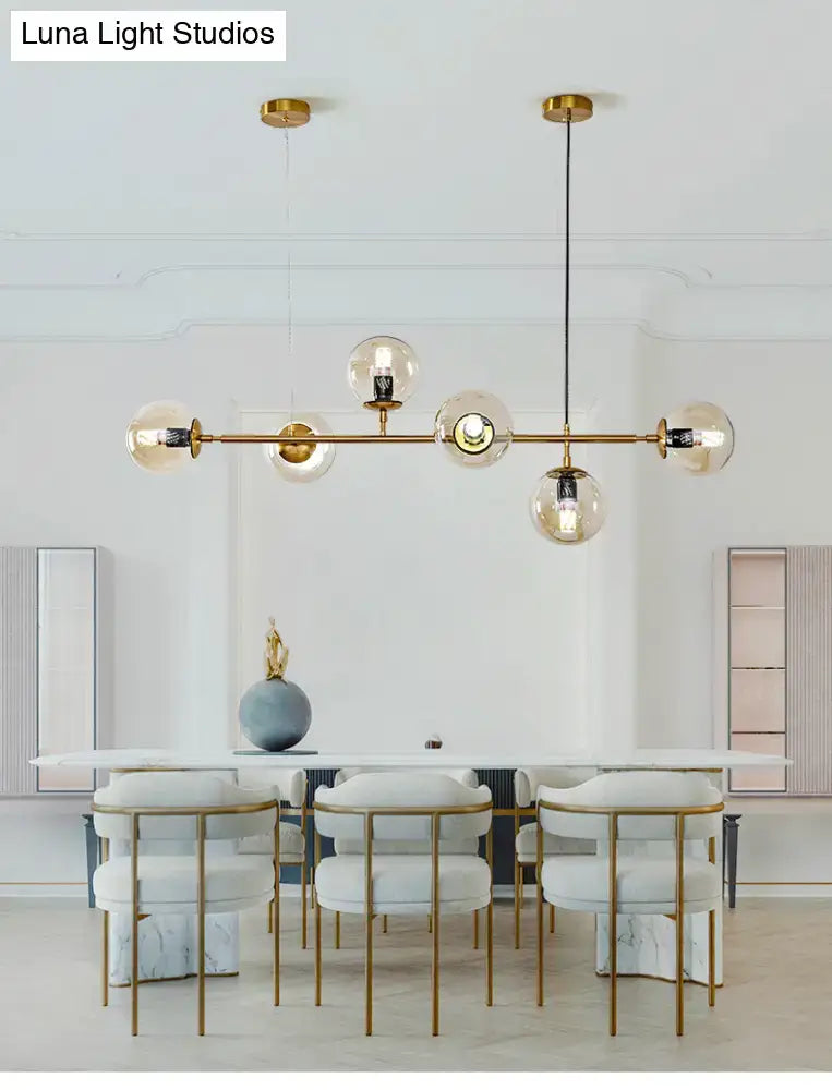 Modern gold island pendant light with gold-tone metal and multiple glass globes for dining room illumination