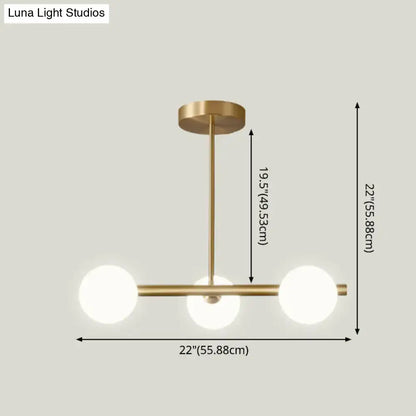 Modern brass island pendant lighting with three spherical white glass globe shades for dining room use