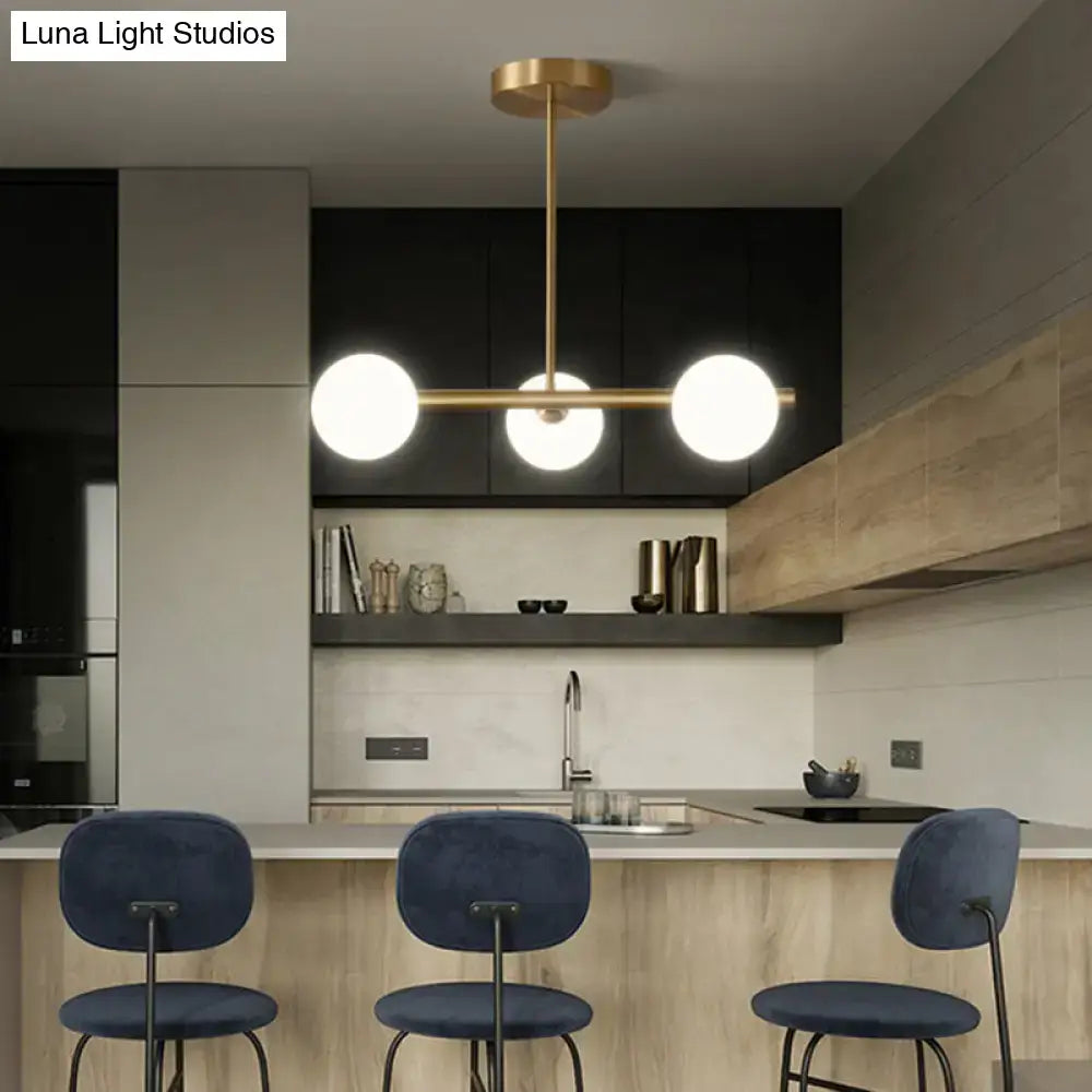Modern gold brass island pendant lighting with three spherical glass globe shades for dining room use