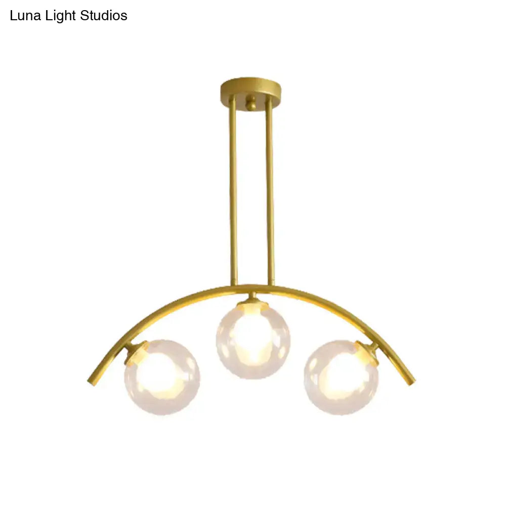 Gold-toned DecorBites island pendant with clear white shade and three spherical glass bulbs for modern kitchens