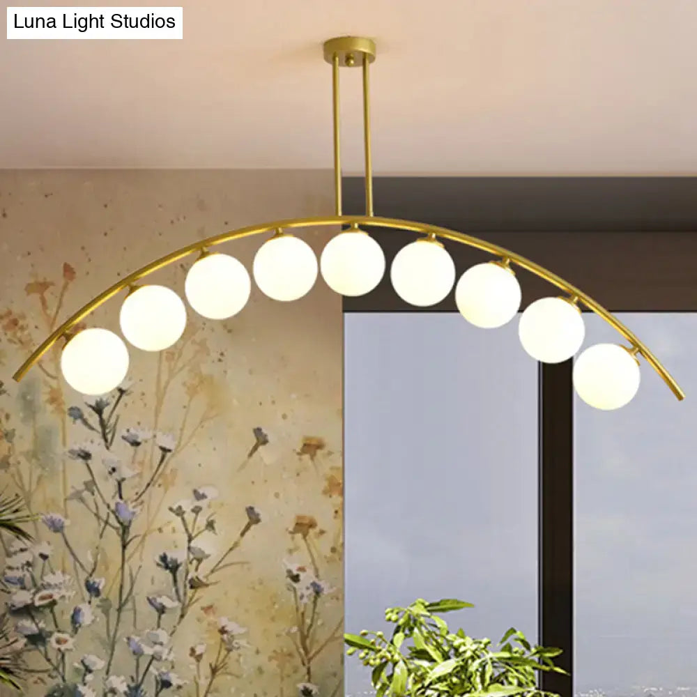 Gold-toned DecorBites island pendant with clear white shade and nine frosted glass globe bulbs for modern kitchens