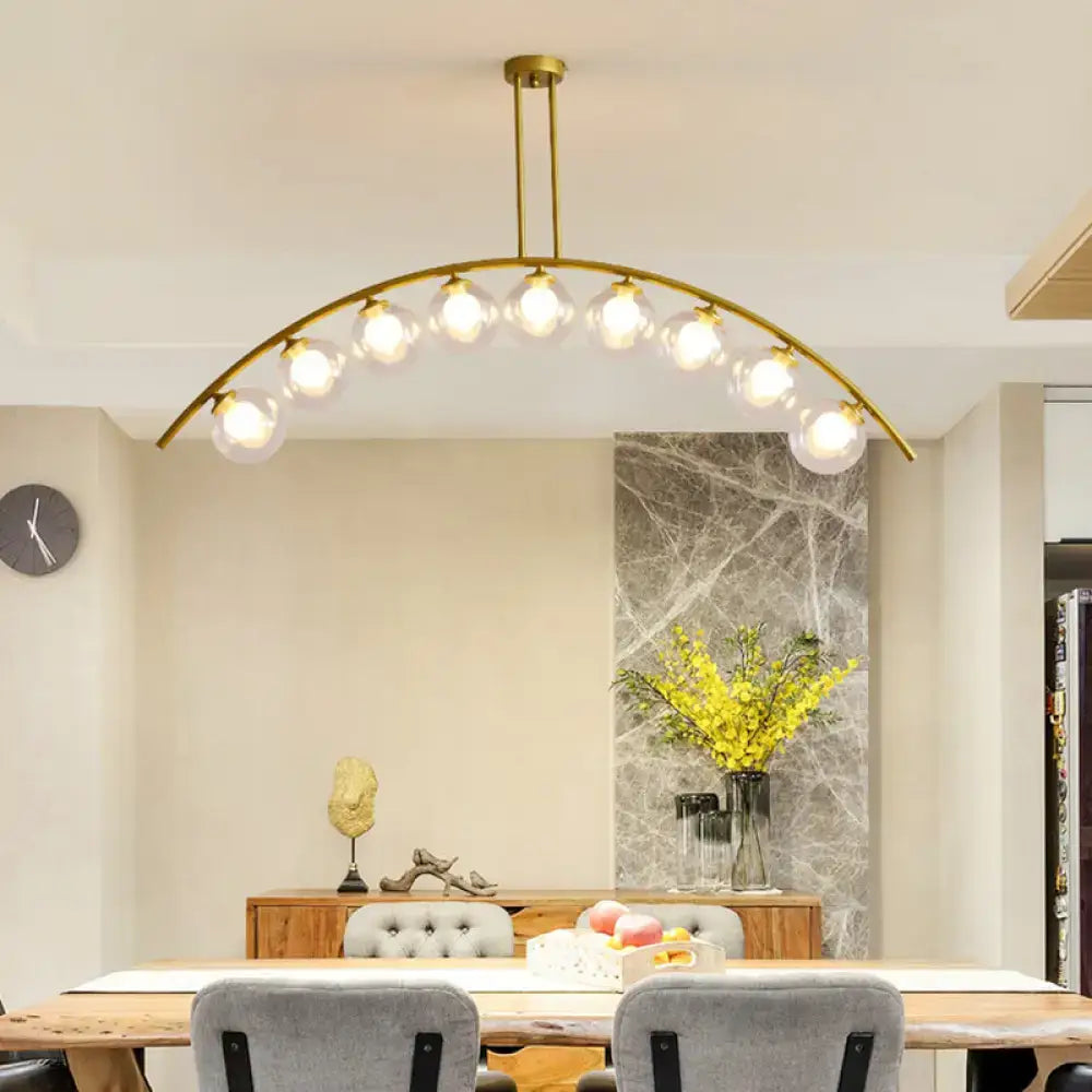 Decorbites gold island pendant with clear white shade featuring gold-toned arches and multiple glass globe bulbs