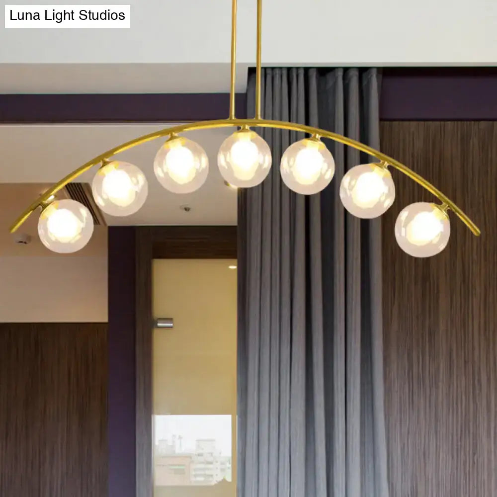 Gold-toned DecorBites island pendant with clear white shade and five frosted glass globes for modern kitchens