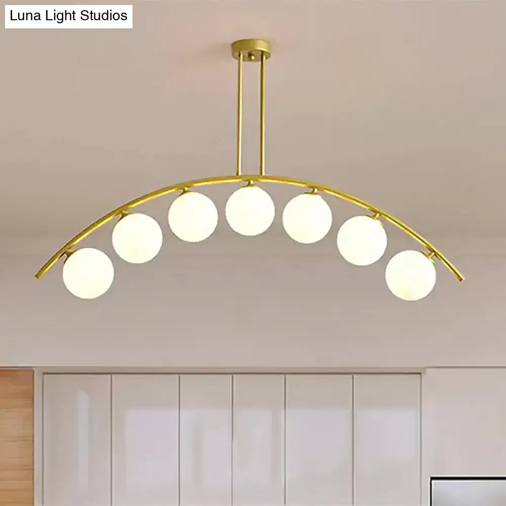 Gold-toned DecorBites island pendant with clear white shade and six frosted glass globe bulbs for modern kitchens