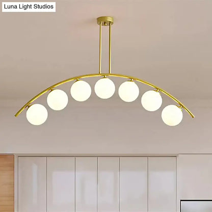 Gold-toned DecorBites island pendant with clear white shade and six frosted glass globe bulbs for modern kitchens