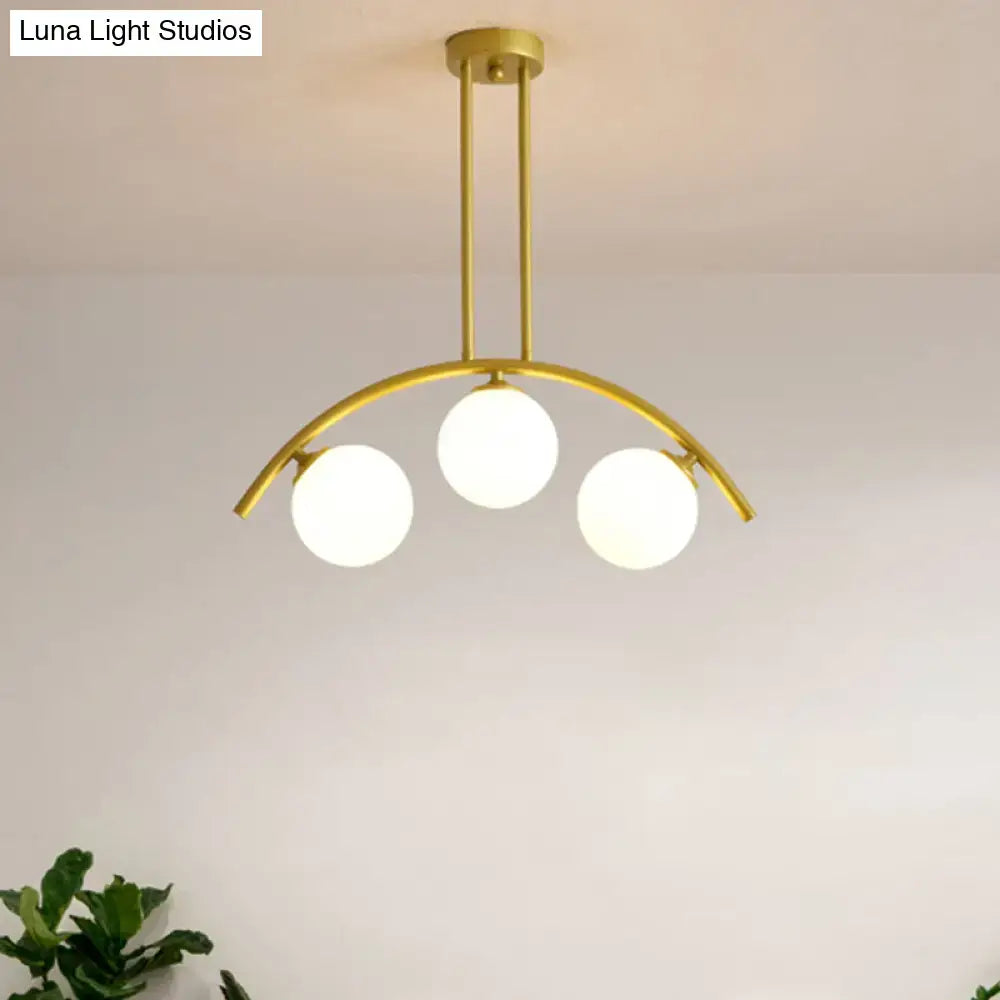 Gold-toned DecorBites island pendant with three frosted globe bulbs and clear white shade perfect for modern kitchens