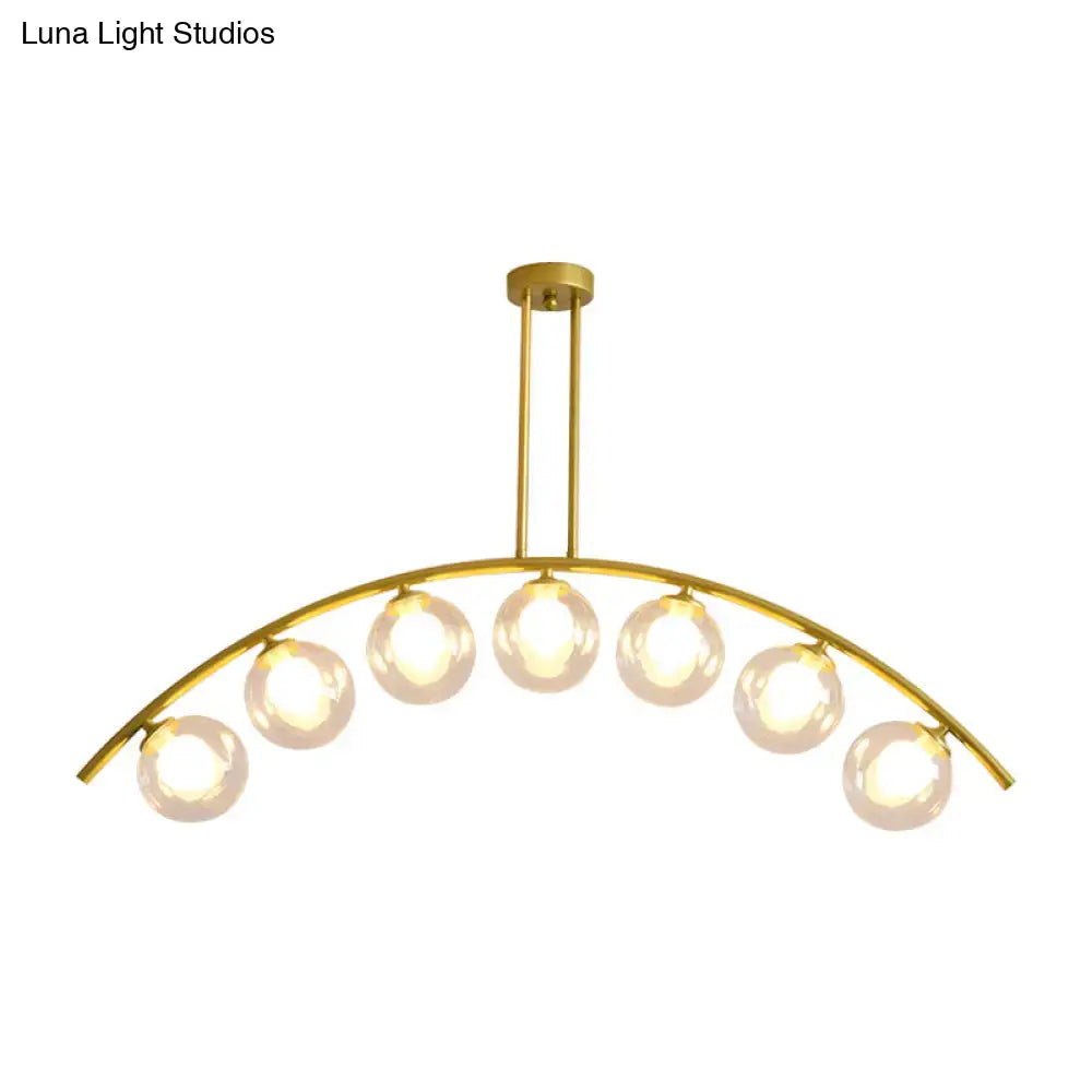 Gold-toned DecorBites island pendant with six frosted glass globe bulbs and clear white shade for modern kitchens