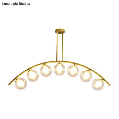 Gold-toned DecorBites island pendant with six frosted glass globe bulbs and clear white shade for modern kitchens