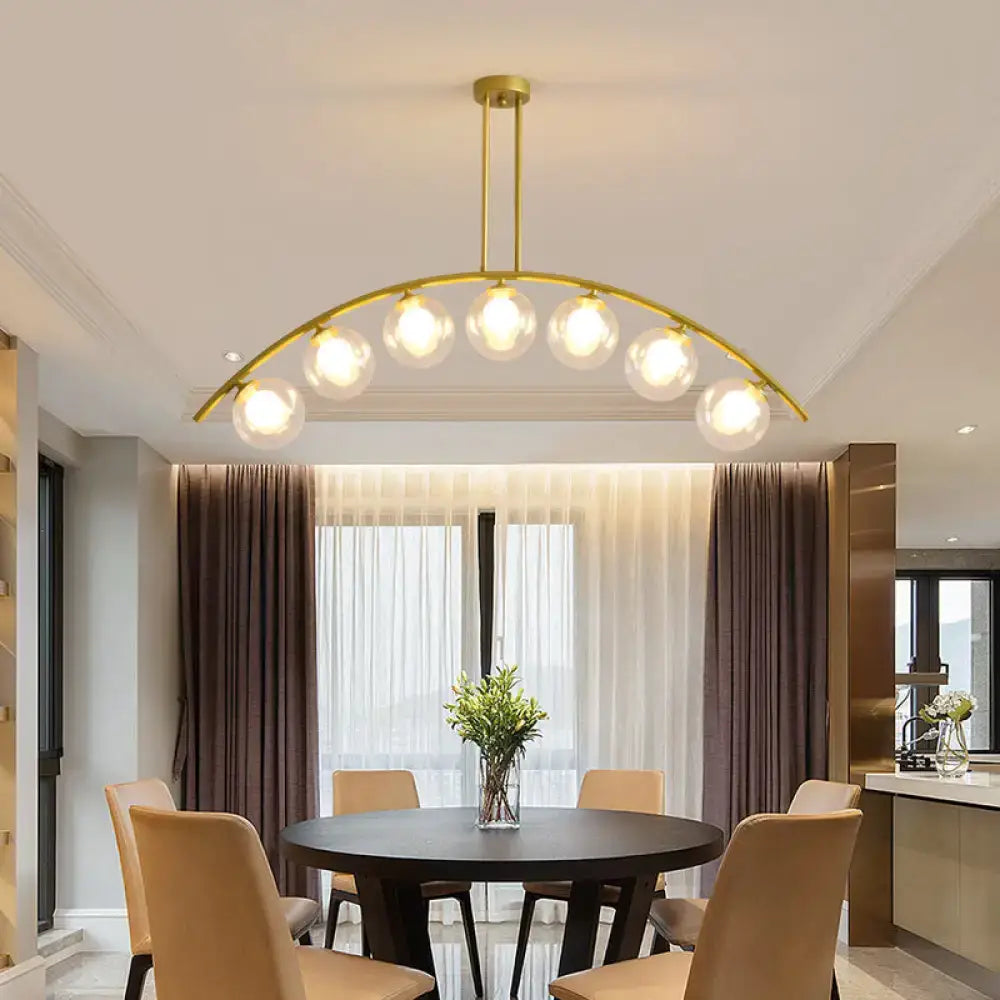 Gold-toned DecorBites island pendant with six clear glass globe bulbs and clear white shade for modern kitchens